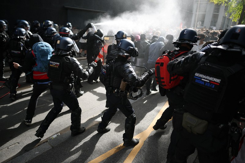 A person carries the French national flag as French high school and university students attend a demonstration in Nantes, part of a nationwide day of protests and blockades to demand better school conditions in France, October 8, 2026. REUTERS/Stephane Mahe