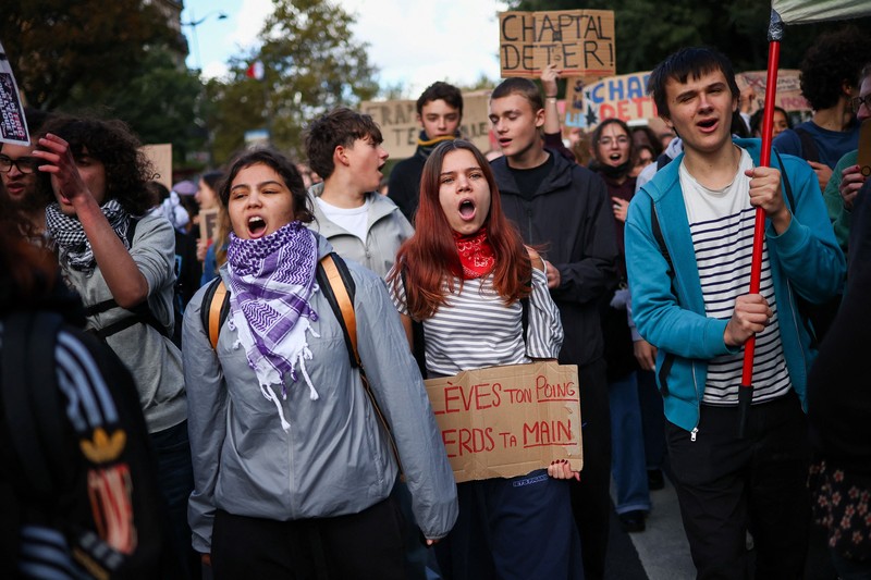 A person carries the French national flag as French high school and university students attend a demonstration in Nantes, part of a nationwide day of protests and blockades to demand better school conditions in France, October 8, 2026. REUTERS/Stephane Mahe
