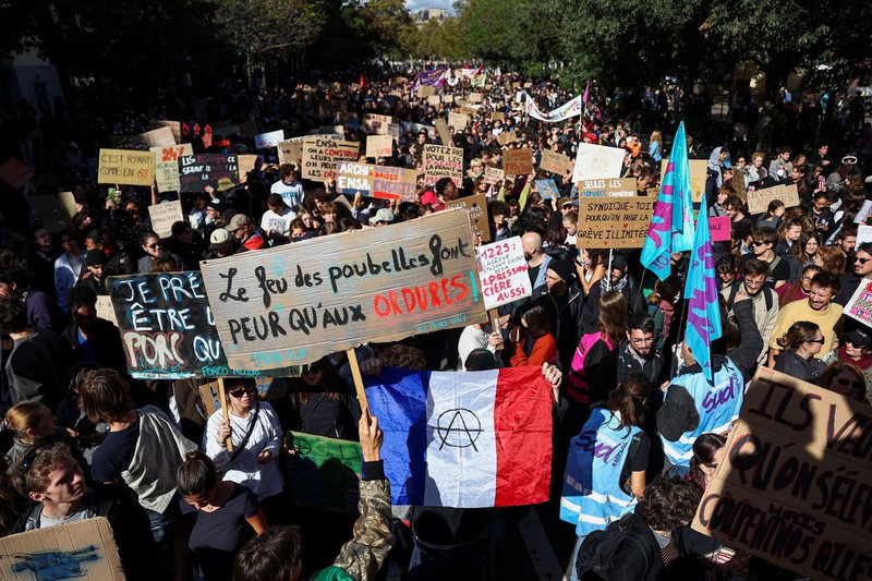 A person carries the French national flag as French high school and university students attend a demonstration in Nantes, part of a nationwide day of protests and blockades to demand better school conditions in France, October 8, 2026. REUTERS/Stephane Mahe