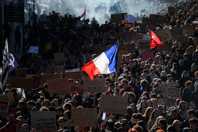 A person carries the French national flag as French high school and university students attend a demonstration in Nantes, part of a nationwide day of protests and blockades to demand better school conditions in France, October 8, 2026. REUTERS/Stephane Mahe