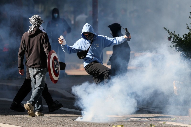 A person carries the French national flag as French high school and university students attend a demonstration in Nantes, part of a nationwide day of protests and blockades to demand better school conditions in France, October 8, 2026. REUTERS/Stephane Mahe