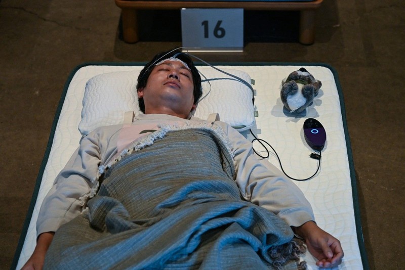 Peserta mengikuti kompetisi tidur yang diselenggarakan oleh sebuah merek kasur di Tokyo, Jepang, Senin (5/10/2026). (AFP/SELIM CHTAYTI)
