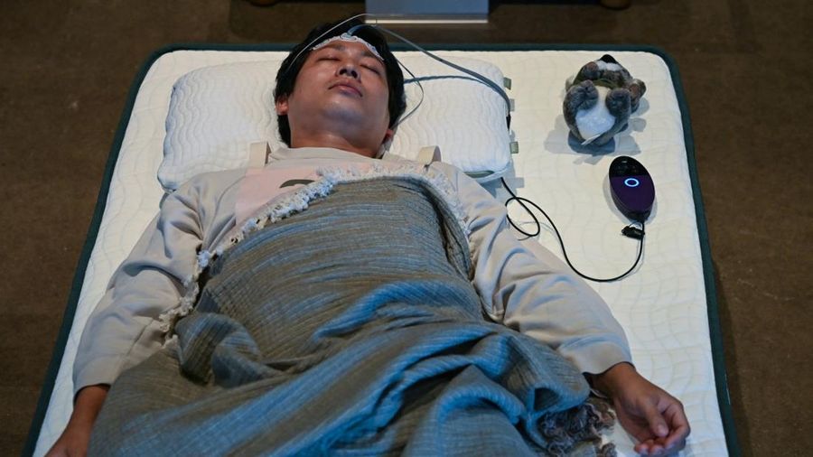 Peserta mengikuti kompetisi tidur yang diselenggarakan oleh sebuah merek kasur di Tokyo, Jepang, Senin (5/10/2026). (AFP/SELIM CHTAYTI)