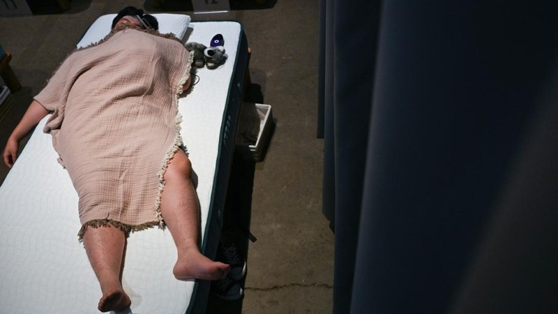 Peserta mengikuti kompetisi tidur yang diselenggarakan oleh sebuah merek kasur di Tokyo, Jepang, Senin (5/10/2026). (AFP/SELIM CHTAYTI)