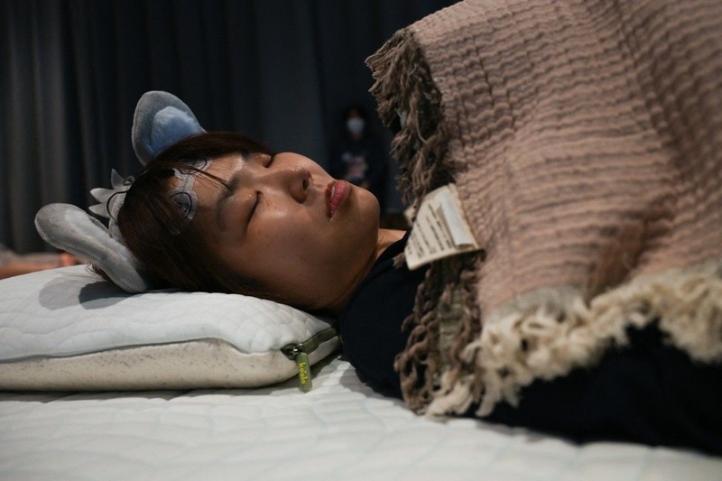 Peserta mengikuti kompetisi tidur yang diselenggarakan oleh sebuah merek kasur di Tokyo, Jepang, Senin (5/10/2026). (AFP/SELIM CHTAYTI)