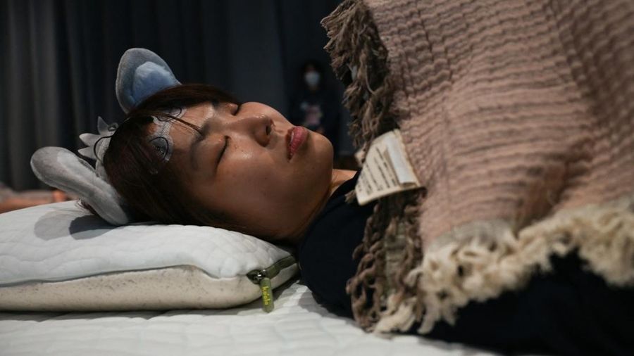 Peserta mengikuti kompetisi tidur yang diselenggarakan oleh sebuah merek kasur di Tokyo, Jepang, Senin (5/10/2026). (AFP/SELIM CHTAYTI)