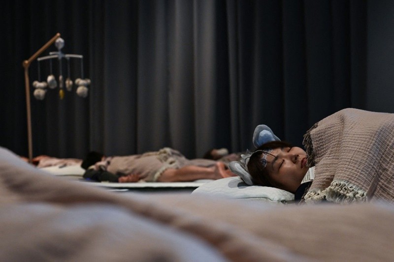 Peserta mengikuti kompetisi tidur yang diselenggarakan oleh sebuah merek kasur di Tokyo, Jepang, Senin (5/10/2026). (AFP/SELIM CHTAYTI)