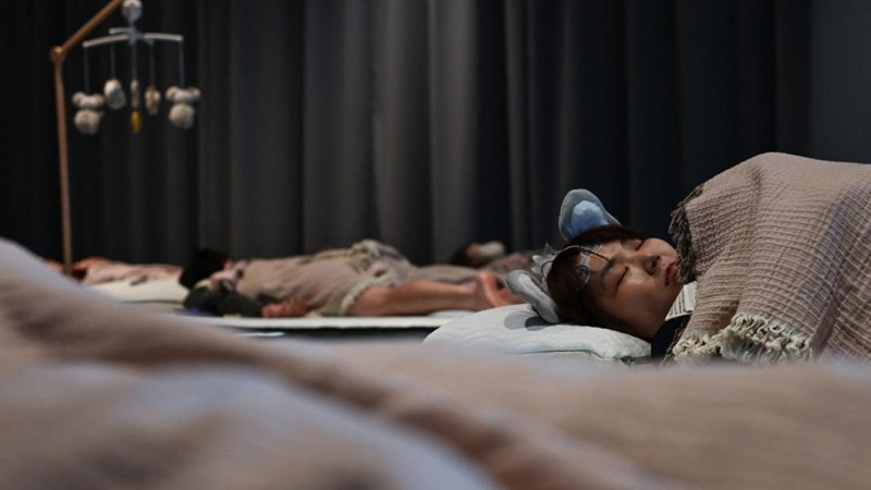 Peserta mengikuti kompetisi tidur yang diselenggarakan oleh sebuah merek kasur di Tokyo, Jepang, Senin (5/10/2026). (AFP/SELIM CHTAYTI)