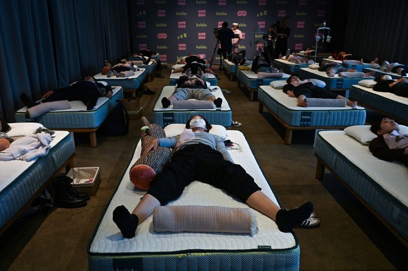 Peserta mengikuti kompetisi tidur yang diselenggarakan oleh sebuah merek kasur di Tokyo, Jepang, Senin (5/10/2026). (AFP/SELIM CHTAYTI)
