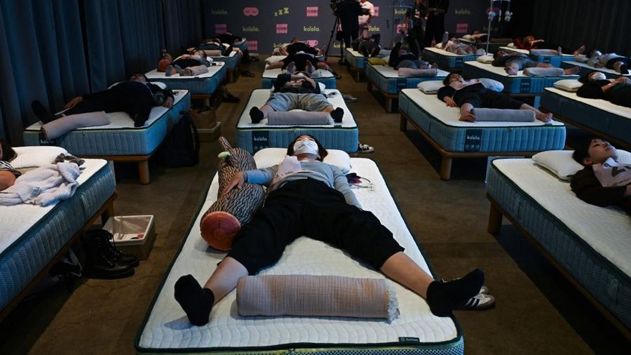 Peserta mengikuti kompetisi tidur yang diselenggarakan oleh sebuah merek kasur di Tokyo, Jepang, Senin (5/10/2026). (AFP/SELIM CHTAYTI)