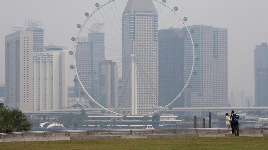 Singapore Flyer dan gedung-gedung komersial diselimuti kabut asap di kawasan Marina Bay, Singapura. (REUTERS/Ore Huiying)