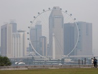 Singapore Flyer dan gedung-gedung komersial diselimuti kabut asap di kawasan Marina Bay, Singapura. (REUTERS/Ore Huiying)