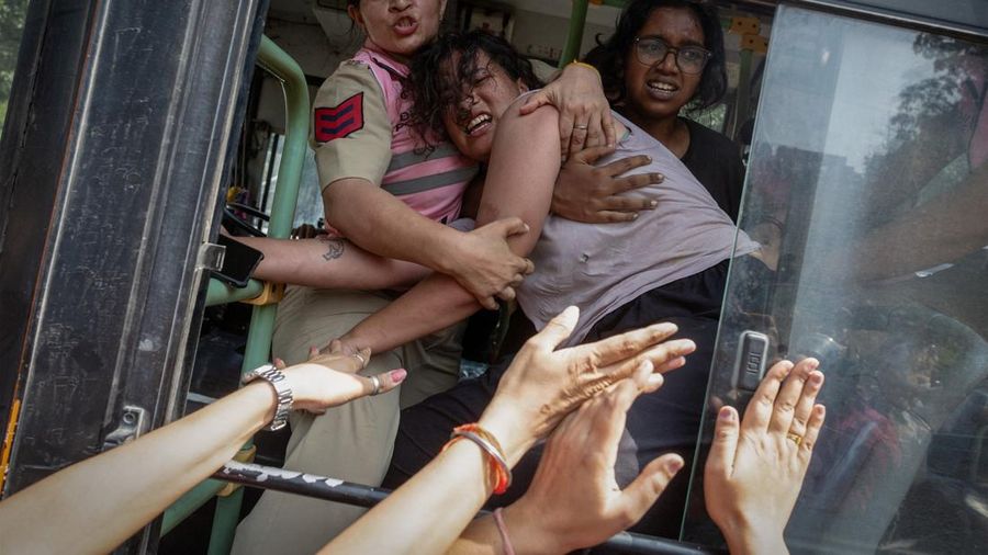 Polisi wanita berupaya mencegah seorang pengunjuk rasa yang telah diamankan melarikan diri dari bus saat aksi protes oleh Cockroach Janta Party (CJP)—yang menuntut pengunduran diri Kepala Komisioner Pemilihan Umum India, Gyanesh Kumar—di dekat lokasi unjuk rasa di New Delhi, India, pada 10 Oktober 2026.