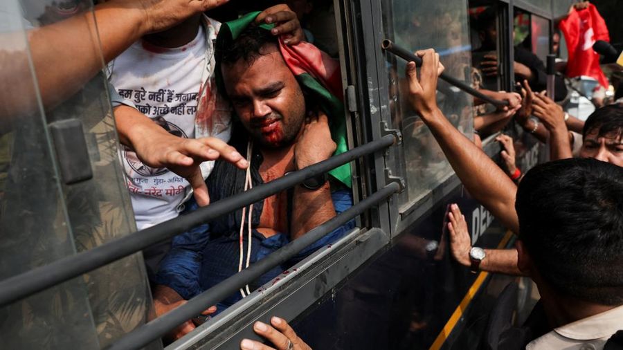 Seorang pengunjuk rasa mengalami pendarahan saat duduk di dalam bus polisi setelah ditahan dalam unjuk rasa yang diselenggarakan oleh Cockroach Janta Party (CJP) untuk menuntut pengunduran diri Kepala Komisioner Pemilihan Umum India, Gyanesh Kumar, di New Delhi, India, pada 10 Oktober 2026.