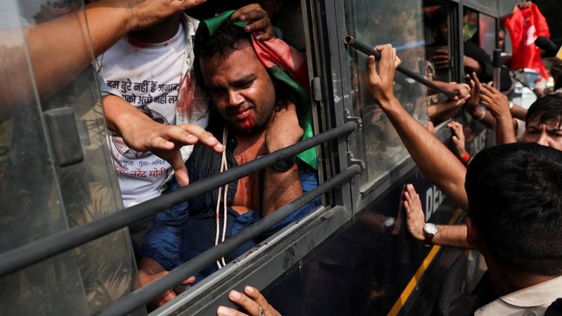 Seorang pengunjuk rasa mengalami pendarahan saat duduk di dalam bus polisi setelah ditahan dalam unjuk rasa yang diselenggarakan oleh Cockroach Janta Party (CJP) untuk menuntut pengunduran diri Kepala Komisioner Pemilihan Umum India, Gyanesh Kumar, di New Delhi, India, pada 10 Oktober 2026.