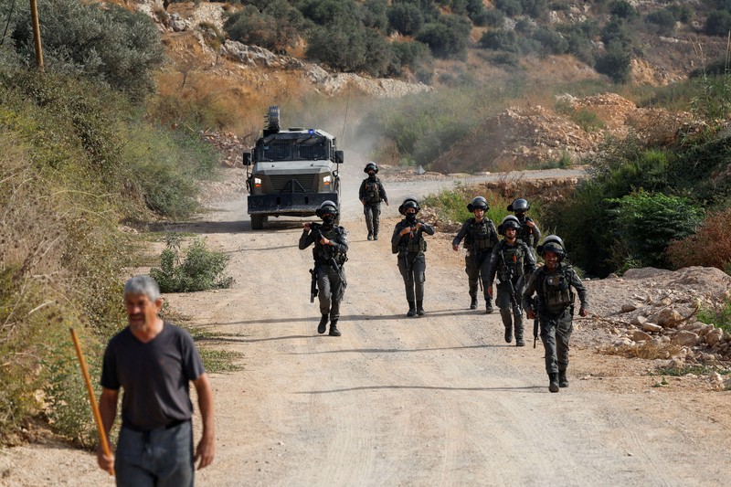 Warga Palestina yang sedang memanen zaitun dan para aktivis asing bereaksi saat terjadi bentrokan dengan pemukim Israel di kebun zaitun milik warga Palestina di desa Deir Abu Mishal&mdash;dengan kepulan asap gas air mata terlihat di latar belakang&mdash;di dekat Ramallah, Tepi Barat yang diduduki Israel, pada 10 Oktober 2026. (REUTERS/Mohamad Torokman)