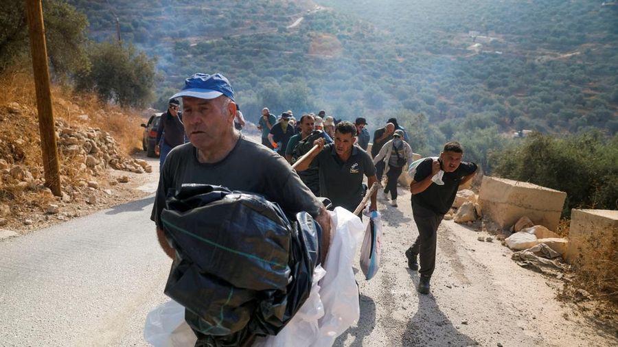Warga Palestina, yang sedang memetik zaitun pada musim panen, bereaksi saat terjadi bentrokan dengan pemukim Israel di kebun zaitun milik warga Palestina di desa Deir Abu Mishal, dekat Ramallah, di Tepi Barat yang diduduki Israel, pada 10 Oktober 2026.