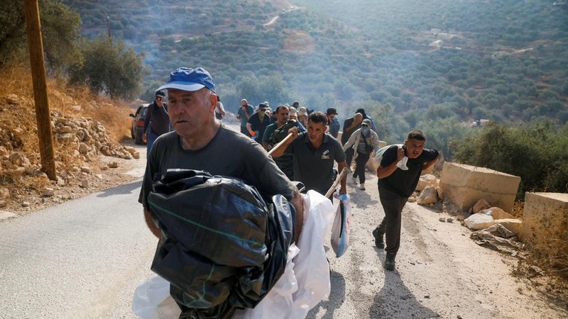 Warga Palestina, yang sedang memetik zaitun pada musim panen, bereaksi saat terjadi bentrokan dengan pemukim Israel di kebun zaitun milik warga Palestina di desa Deir Abu Mishal, dekat Ramallah, di Tepi Barat yang diduduki Israel, pada 10 Oktober 2026.