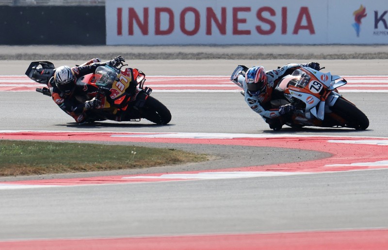 Pembalap Aprilia Racing Marco Bezzecchi merayakan kemenangan di atas podium sambil mengangkat trofi setelah memenangi balapan MotoGP Grand Prix Indonesia 2026, bersama pembalap Trackhouse MotoGP Team Raul Fernandez yang finis kedua dan pembalap Aprilia Racing Jorge Martin yang menempati posisi ketiga, di Sirkuit Internasional Mandalika, Mandalika, Indonesia, (11/10/2026). (REUTERS/Willy Kurniawan)
