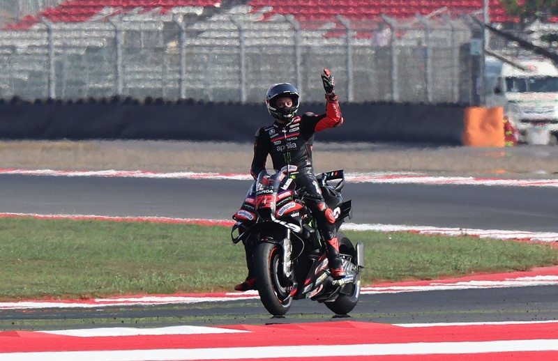 Pembalap Aprilia Racing Marco Bezzecchi merayakan kemenangan di atas podium sambil mengangkat trofi setelah memenangi balapan MotoGP Grand Prix Indonesia 2026, bersama pembalap Trackhouse MotoGP Team Raul Fernandez yang finis kedua dan pembalap Aprilia Racing Jorge Martin yang menempati posisi ketiga, di Sirkuit Internasional Mandalika, Mandalika, Indonesia, (11/10/2026). (REUTERS/Willy Kurniawan)