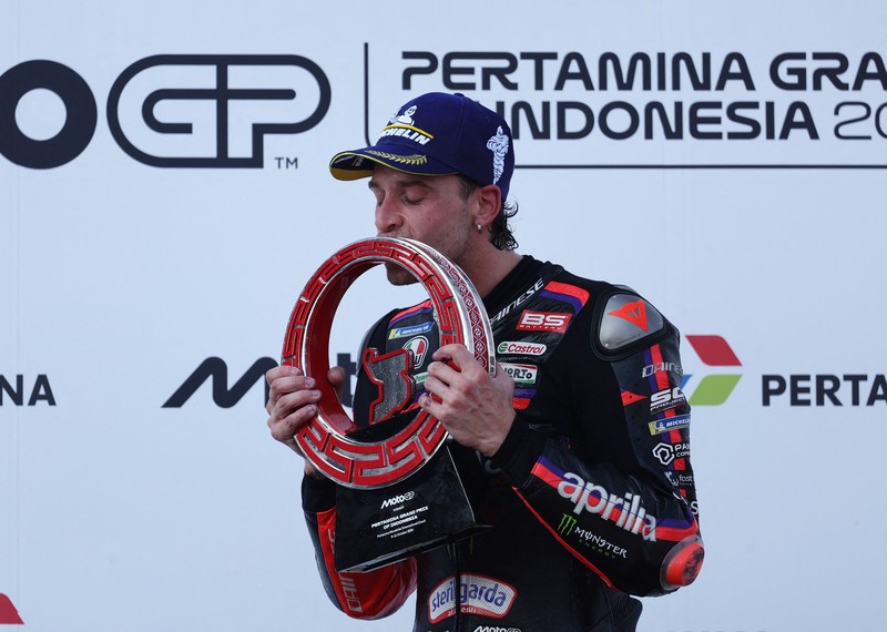 Pembalap Aprilia Racing Marco Bezzecchi merayakan kemenangan di atas podium sambil mengangkat trofi setelah memenangi balapan MotoGP Grand Prix Indonesia 2026, bersama pembalap Trackhouse MotoGP Team Raul Fernandez yang finis kedua dan pembalap Aprilia Racing Jorge Martin yang menempati posisi ketiga, di Sirkuit Internasional Mandalika, Mandalika, Indonesia, (11/10/2026). (REUTERS/Willy Kurniawan)
