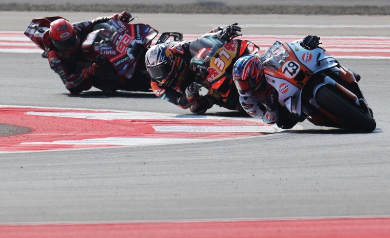 Pembalap Aprilia Racing Marco Bezzecchi merayakan kemenangan di atas podium sambil mengangkat trofi setelah memenangi balapan MotoGP Grand Prix Indonesia 2026, bersama pembalap Trackhouse MotoGP Team Raul Fernandez yang finis kedua dan pembalap Aprilia Racing Jorge Martin yang menempati posisi ketiga, di Sirkuit Internasional Mandalika, Mandalika, Indonesia, (11/10/2026). (REUTERS/Willy Kurniawan)
