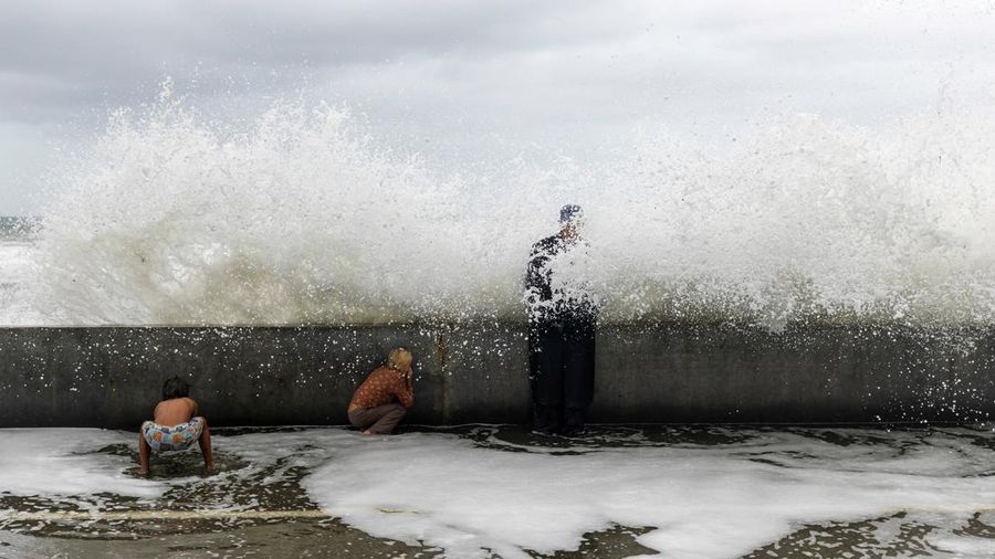 Anak-anak kecil bermain di tengah cipratan ombak akibat siklon pasca-tropis Rachel saat Bruce Parker menghadapi dampaknya di sepanjang garis pantai di Oceanside, California, AS, pada 11 Oktober 2026.