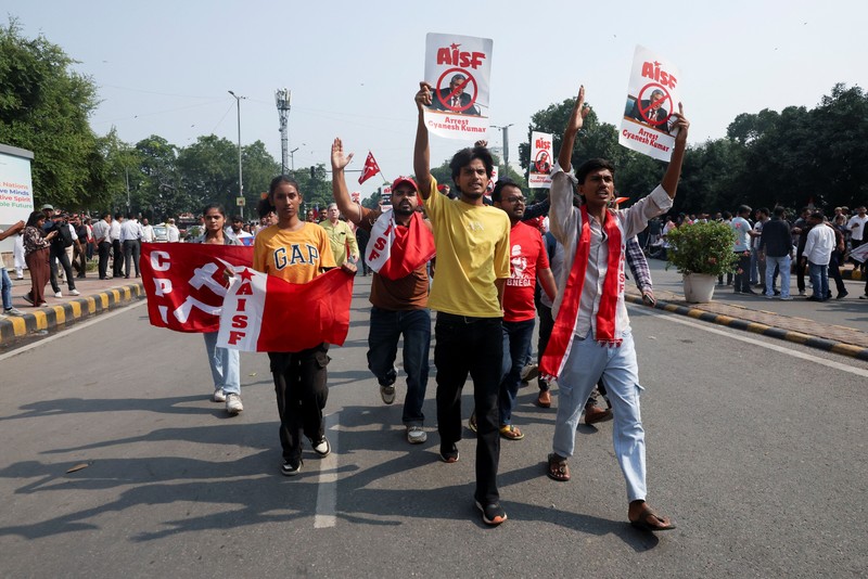 Para pendukung partai oposisi berdiri di atas bus dengan membawa plakat dan bendera sambil berbaris menuju Mahkamah Agung untuk memprotes revisi daftar pemilih yang kontroversial yang telah memicu kerusuhan selama beberapa hari, di New Delhi, India, 12 Oktober 2026. (REUTERS/Priyanshu Singh)