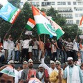 Para pendukung partai oposisi berdiri di atas bus dengan membawa plakat dan bendera sambil berbaris menuju Mahkamah Agung untuk memprotes revisi daftar pemilih yang kontroversial yang telah memicu kerusuhan selama beberapa hari, di New Delhi, India,