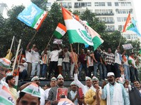 Para pendukung partai oposisi berdiri di atas bus dengan membawa plakat dan bendera sambil berbaris menuju Mahkamah Agung untuk memprotes revisi daftar pemilih yang kontroversial yang telah memicu kerusuhan selama beberapa hari, di New Delhi, India,