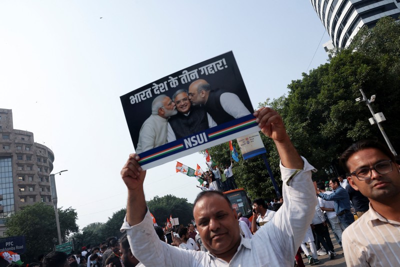 Para pendukung partai oposisi berdiri di atas bus dengan membawa plakat dan bendera sambil berbaris menuju Mahkamah Agung untuk memprotes revisi daftar pemilih yang kontroversial yang telah memicu kerusuhan selama beberapa hari, di New Delhi, India, 12 Oktober 2026. (REUTERS/Priyanshu Singh)