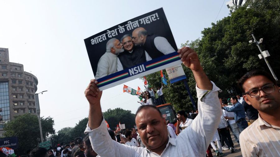 Para pendukung partai oposisi berdiri di atas bus dengan membawa plakat dan bendera sambil berbaris menuju Mahkamah Agung untuk memprotes revisi daftar pemilih yang kontroversial yang telah memicu kerusuhan selama beberapa hari, di New Delhi, India, 12 Oktober 2026. (REUTERS/Priyanshu Singh)