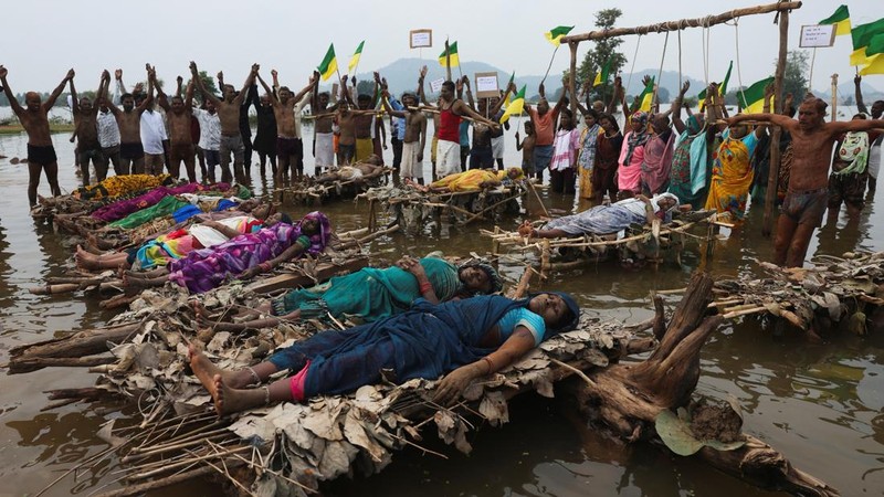 Para pengunjuk rasa dan anggota keluarga yang terdampak Proyek Penghubung Sungai Ken-Betwa berbaring di atas tumpukan kayu bakar untuk upacara kremasi simbolis yang ditempatkan di dalam air, sementara yang lain berdiri di bawah kerangka kayu dengan jerat tali simbolis melingkar di leher mereka dalam sebuah aksi protes di dekat Bendungan Majhgawan di Sungai Ken, Ajaygarh, Madhya Pradesh, India, pada 20 September 2026.