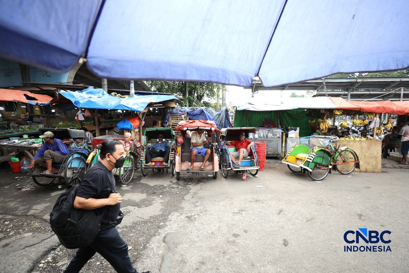 Seorang tukang becak mengantar seorang penumpang menggunakan becak listrik di Pasar Depok Jaya, Jawa Barat, Senin (12/10/2026). (CNBC Indonesia/Tri Susilo)