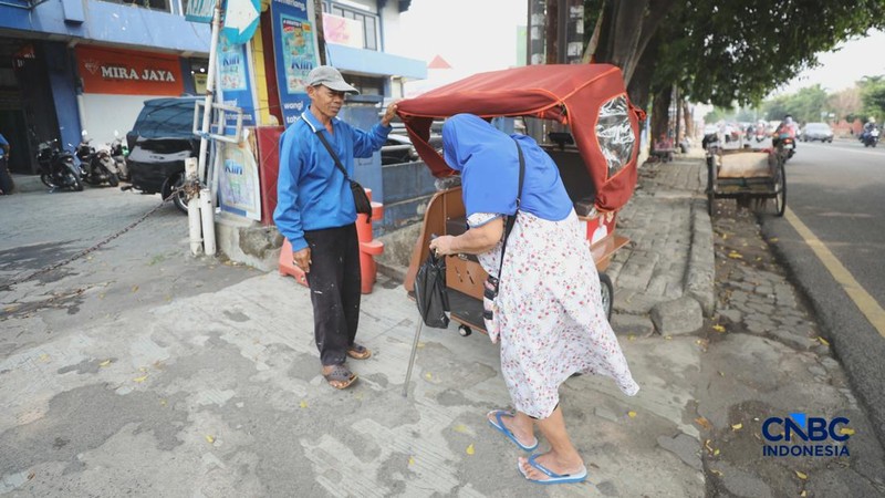 Seorang tukang becak mengantar seorang penumpang menggunakan becak listrik di Pasar Depok Jaya, Jawa Barat, Senin (12/10/2026). (CNBC Indonesia/Tri Susilo)