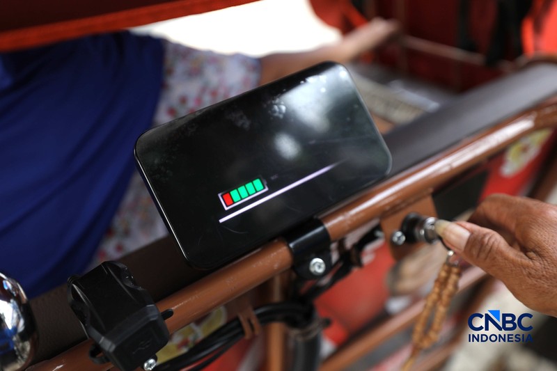 Seorang tukang becak mengantar seorang penumpang menggunakan becak listrik di Pasar Depok Jaya, Jawa Barat, Senin (12/10/2026). (CNBC Indonesia/Tri Susilo)
