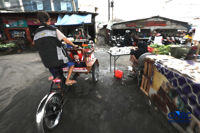 Seorang tukang becak mengantar seorang penumpang menggunakan becak listrik di Pasar Depok Jaya, Jawa Barat, Senin (12/10/2026). (CNBC Indonesia/Tri Susilo)