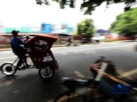 Seorang tukang becak mengantar seorang penumpang menggunakan becak listrik di Pasar Depok Jaya, Jawa Barat, Senin (12/10/2026). (CNBC Indonesia/Tri Susilo)