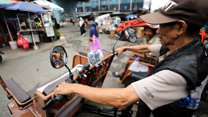 Seorang tukang becak mengantar seorang penumpang menggunakan becak listrik di Pasar Depok Jaya, Jawa Barat, Senin (12/10/2026).