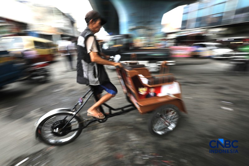 Seorang tukang becak mengantar seorang penumpang menggunakan becak listrik di Pasar Depok Jaya, Jawa Barat, Senin (12/10/2026). (CNBC Indonesia/Tri Susilo)