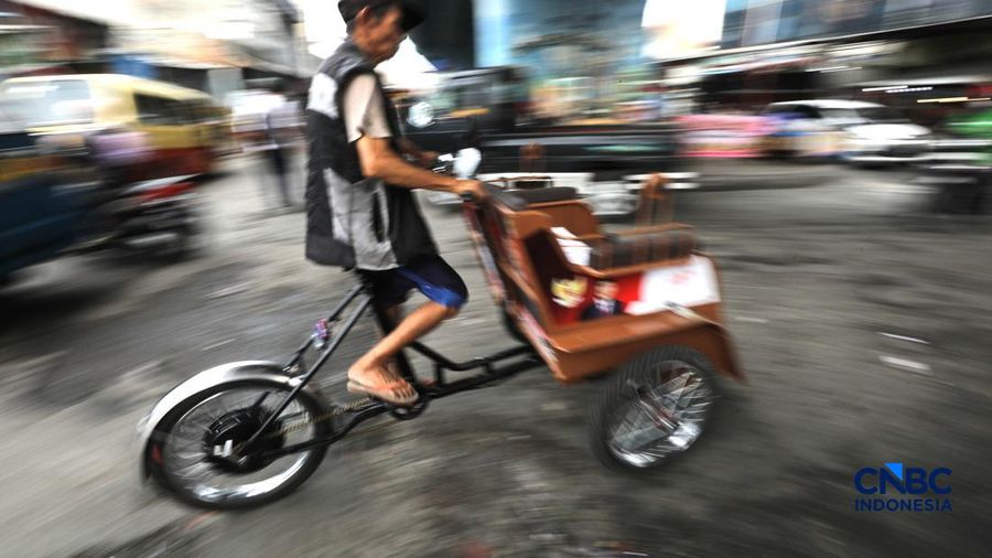 Seorang tukang becak mengantar seorang penumpang menggunakan becak listrik di Pasar Depok Jaya, Jawa Barat, Senin (12/10/2026).