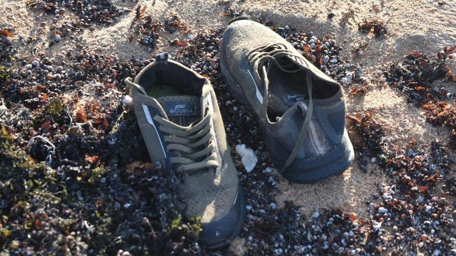 Sepasang sepatu yang diduga milik seorang migran tergeletak di tepi pantai setelah sebuah kapal yang mengangkut sekitar 305 orang terbalik saat berlayar dari Djibouti menuju Yaman—peristiwa yang menewaskan sedikitnya 109 migran, termasuk 15 anak-anak, dan menyebabkan lebih dari 116 orang hilang—menurut Organisasi Internasional untuk Migrasi (IOM) PBB pada 11 Oktober; lokasi kejadian berada di dekat Guhere, sebelah utara kota pelabuhan Obock, Djibouti, sebagaimana terlihat dalam foto yang dirilis pada 10 Oktober 2026 ini.