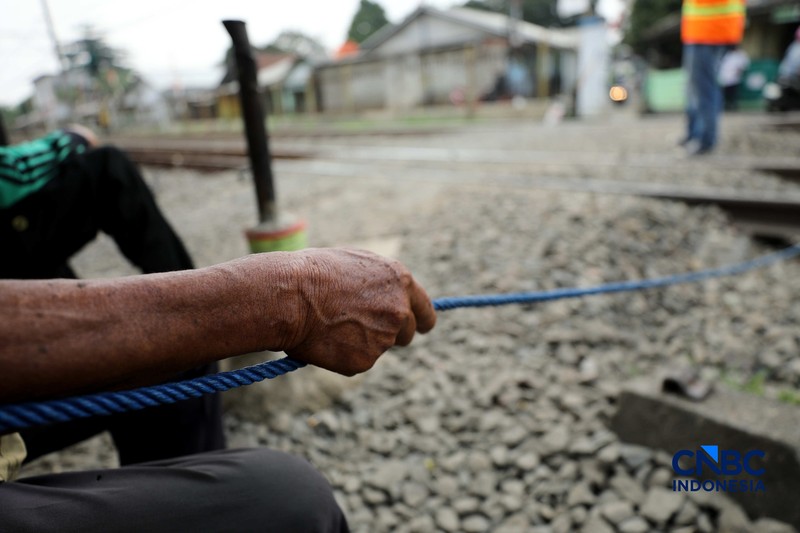 Suasana palang pintu kereta yang dibuat oleh sekelompok warga secara sukarela di Desa Bambu Kuning, Bojonggede, Jawa Barat, Senin (12/10/2026). (CNBC Indonesia/Tri Susilo)