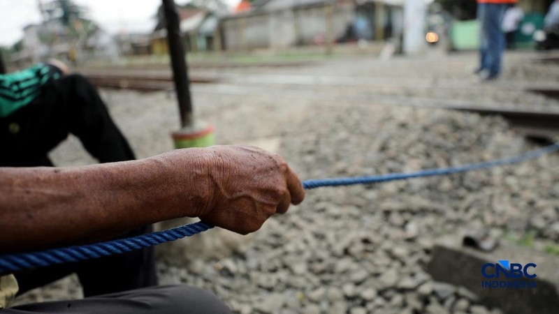 Suasana palang pintu kereta yang dibuat oleh sekelompok warga secara sukarela di Desa Bambu Kuning, Bojonggede, Jawa Barat, Senin (12/10/2026). (CNBC Indonesia/Tri Susilo)