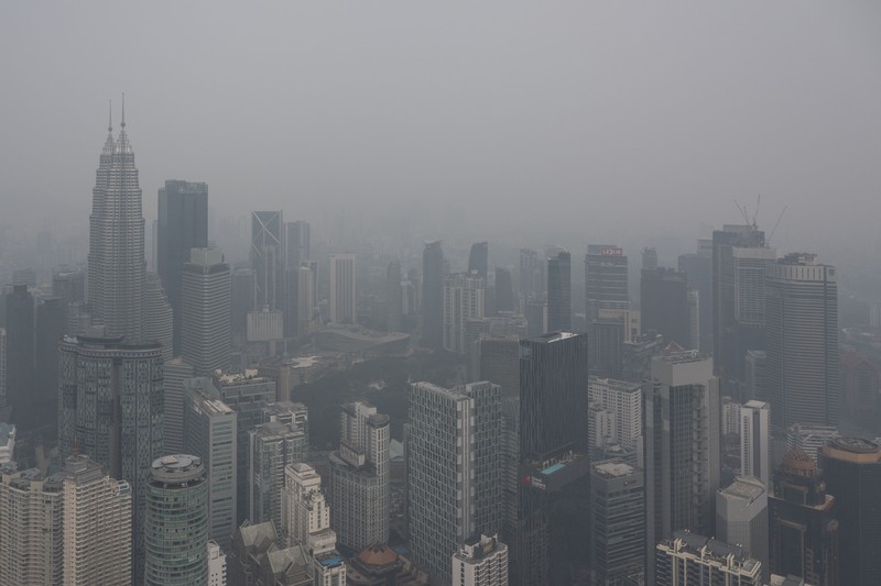 Gedung-gedung komersial terlihat diselimuti kabut di Kuala Lumpur, Malaysia, Selasa (13/10/2026). (Mohd Rasfan / AFP)