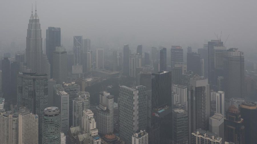 Gedung-gedung komersial terlihat diselimuti kabut di Kuala Lumpur, Malaysia, Selasa (13/10/2026). (Mohd Rasfan / AFP)