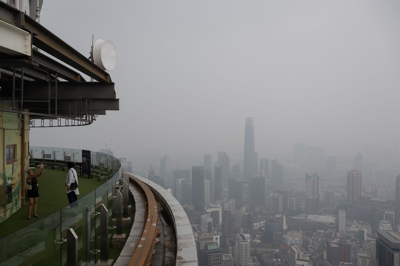 Gedung-gedung komersial terlihat diselimuti kabut di Kuala Lumpur, Malaysia, Selasa (13/10/2026). (Mohd Rasfan / AFP)