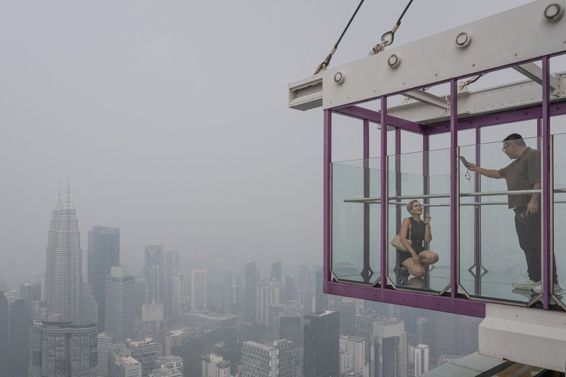 Gedung-gedung komersial terlihat diselimuti kabut di Kuala Lumpur, Malaysia, Selasa (13/10/2026). (Mohd Rasfan / AFP)