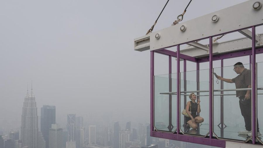Gedung-gedung komersial terlihat diselimuti kabut di Kuala Lumpur, Malaysia, Selasa (13/10/2026). (Mohd Rasfan / AFP)