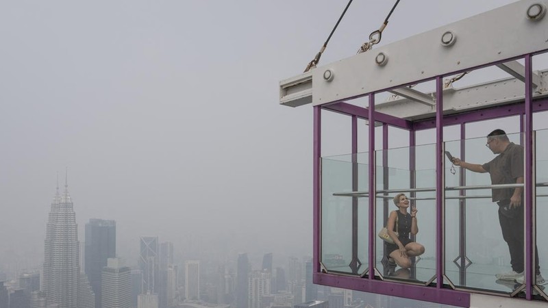 Gedung-gedung komersial terlihat diselimuti kabut di Kuala Lumpur, Malaysia, Selasa (13/10/2026). (Mohd Rasfan / AFP)